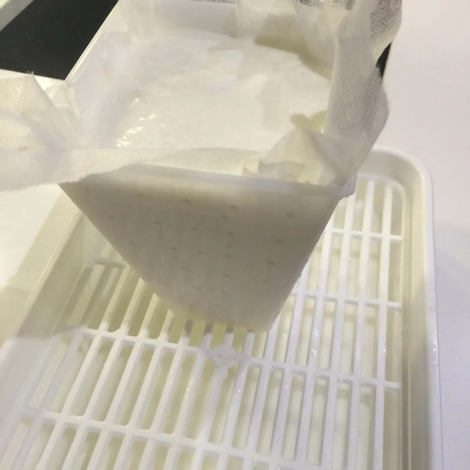 Molde forrado con tela quesera recibiendo la cuajada fresca